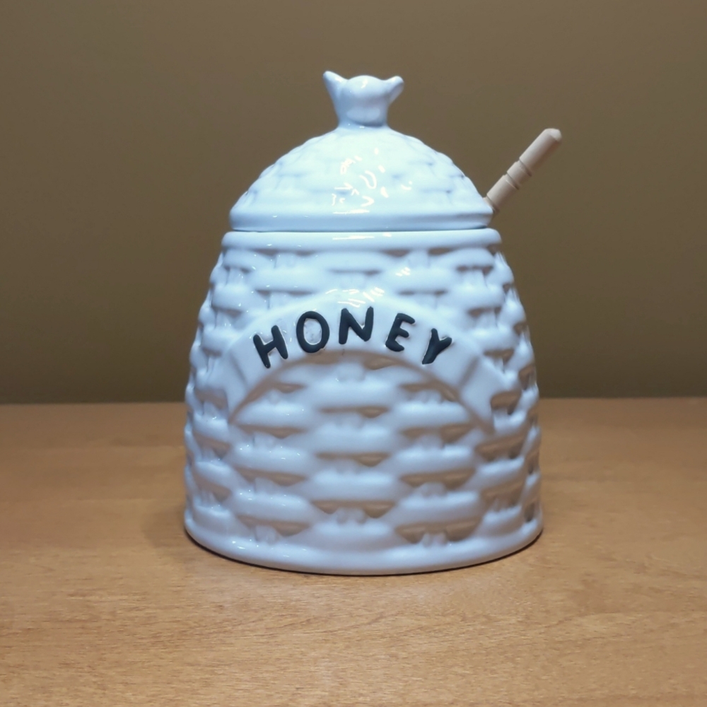 Large white honey pot with honey dipper